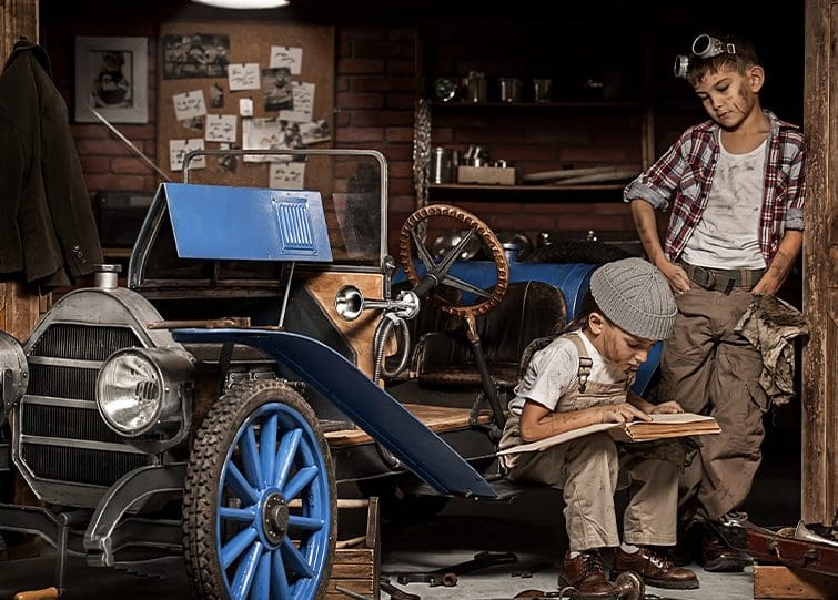 GCA two young boys work on a vintage car in the garage