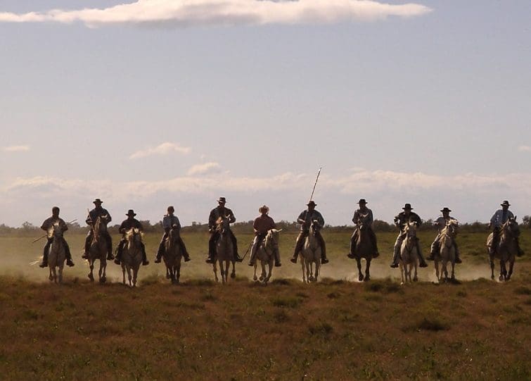 GCA cowboys riding horses in a straightline