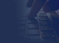 GCA person typing on laptop with dark navy overlay
