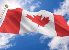 Canadian flag waving in blue sky