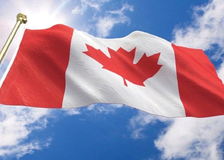Canadian flag waving in blue sky