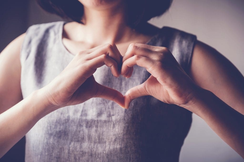 A person making a heart shape with their hands.