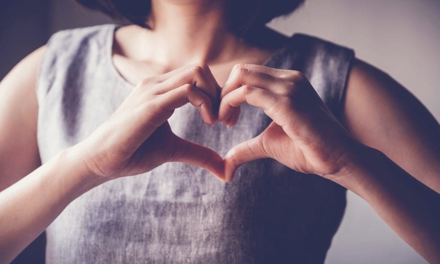 A person making a heart shape with their hands.