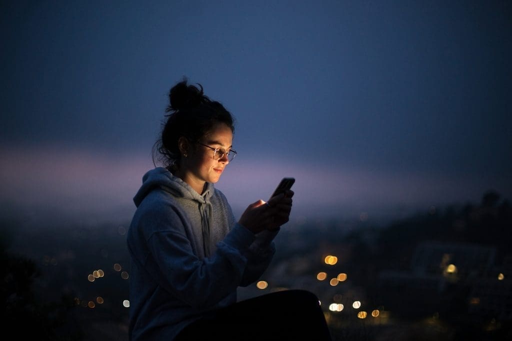 A person with glasses on their phone.