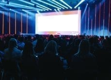 People in audience watching a large stage.