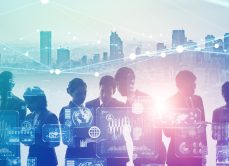 Abstract outlines of group of people with technology overlay with cityscape in the background
