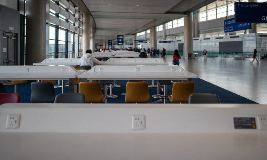 Workstations with charging ports and free WiFi at Shanghai Pudong International Airport. People use laptops and phones in coworking space while waiting for flights. 03 April 2025. Shanghai, China